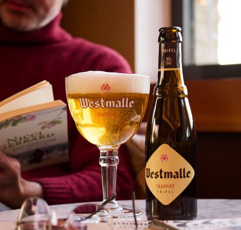 We’re pouring one of the most influential beers in the world — Westmalle Tripel, again from Westmalle Abbey.

Originally brewed in 1934, Westmalle Tripel is widely considered the very first modern Tripel — the blueprint for the style that breweries everywhere now replicate.

What makes a Tripel?
Stronger, pale in color, highly carbonated, and deceptively drinkable for its strength.

Flavor Profile:
🍯 Honeyed malt sweetness
🍌 Classic Belgian yeast esters (banana, pear)
🌶 Soft spice & clove notes
🌼 Floral hop aroma
✨ Dry, effervescent finish

ABV: 9.5% — bold yet dangerously smooth.

Fun Fact: Despite the name “Tripel,” it doesn’t mean triple the alcohol — it historically referred to a stronger version of the monastery’s standard beer.

This is one of the most important beers in Belgian brewing history.

🍺 Limited pours
🎁 Stickers while they last
🙏 Raise your chalice